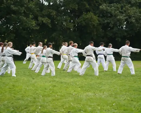 Groep karateka's oefent stoottechnieken in zenkutsu-dachi