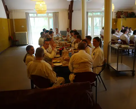 Gezamenlijke maaltijd in het boshuis tijdens de weekendtraining