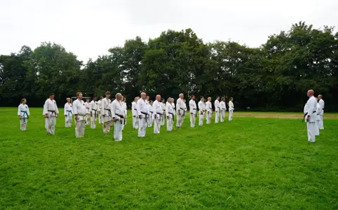 Karateka's staan in rijen klaar voor de volgende oefening