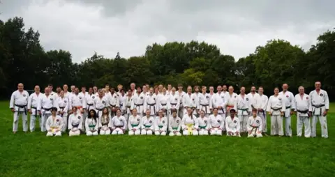 Groepsfoto van alle deelnemers aan de weekendtraining op het grasveld