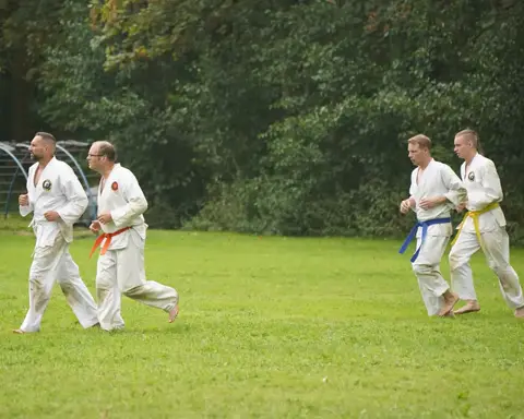 Karateka's rennen tijdens de warming-up