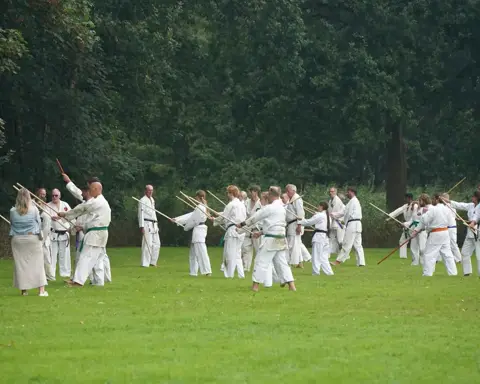 Jeugd en volwassenen trainen in paren op het grote grasveld