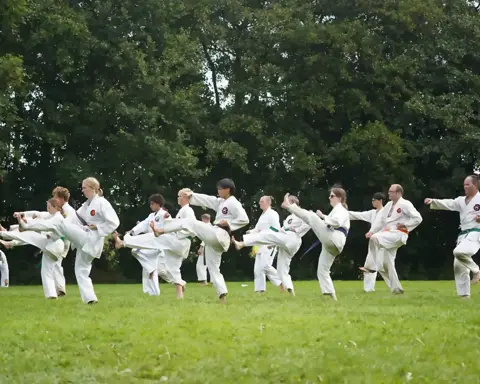 Groep oefent mae-geri schoptechnieken