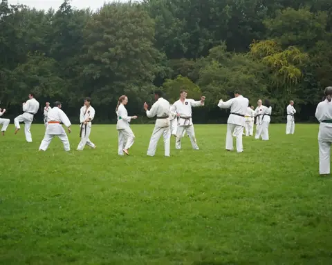 Karateka's oefenen partnertechnieken op het veld