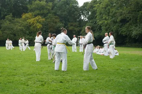 Partneroefening met een karateka met gele band onder begeleiding