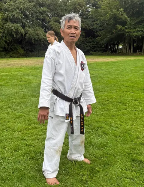 Sensei met zwarte band op het trainingsveld