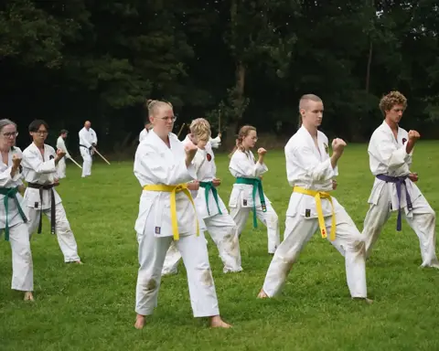 Karateka's van alle leeftijden oefenen kihon