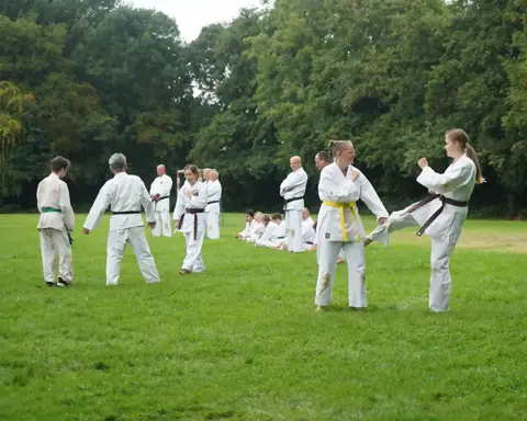 Twee karateka's oefenen een schoptechniek samen