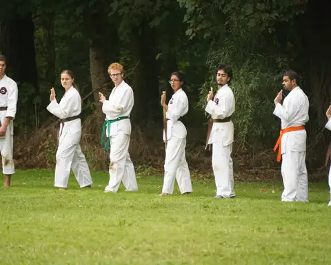 Karateka's in kamae-houding tijdens de buitentraining