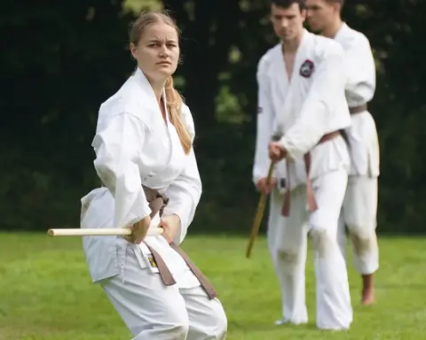 Zwarte banden bespreken een jo-techniek tijdens de weekendtraining
