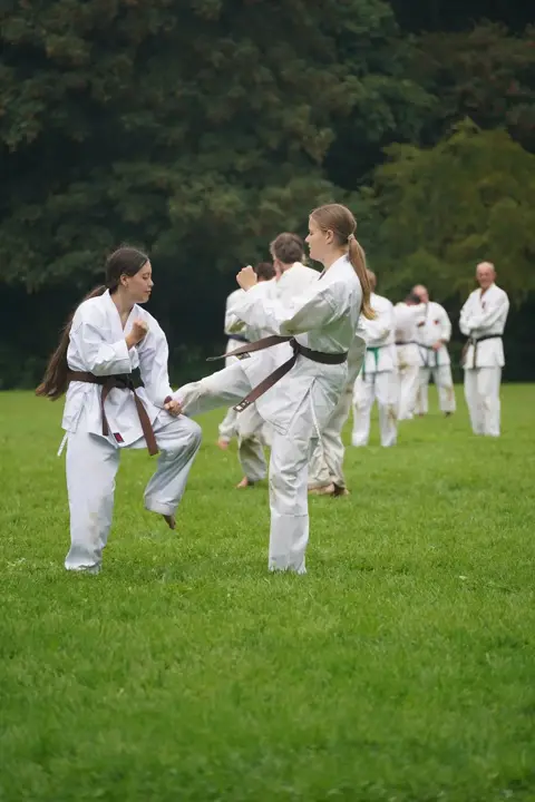 Twee karateka's oefenen samen een traptechniek