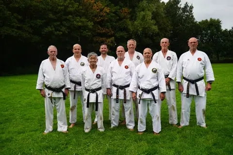 De senseis en zwarte banden van de weekendtraining op een rij
