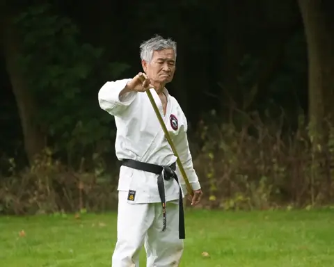 Vier karateka's oefenen stoottechnieken met de jo-staf