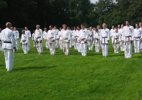 Deelnemers lopen over het veld tijdens de warming-up