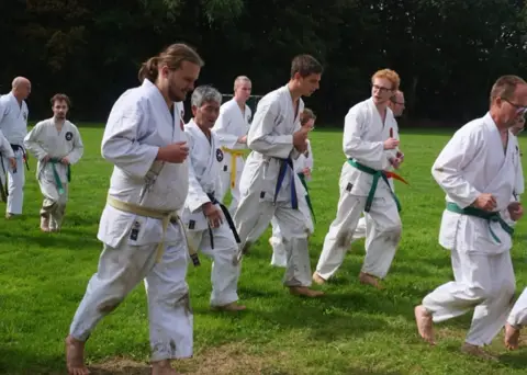 Karateka's oefenen lage standen tijdens de gasshuku