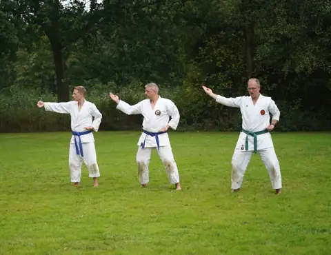 Karateka's oefenen een stoot in voorwaartse stand