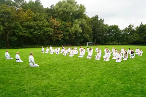 Groep zit in seiza met de sensei vooraan