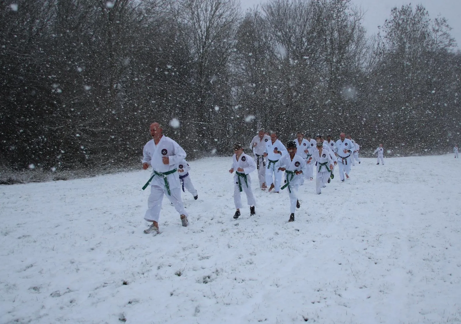 Groep rent door besneeuwd veld tijdens conditietraining